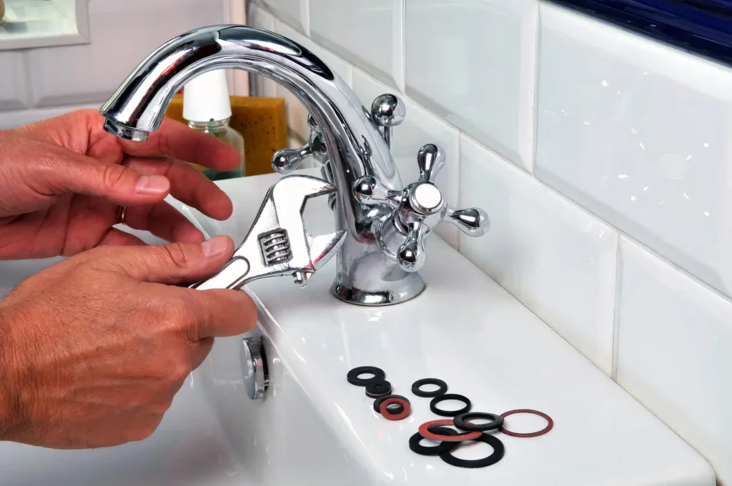 Plumber performing maintenance on a bathroom faucet in Athens